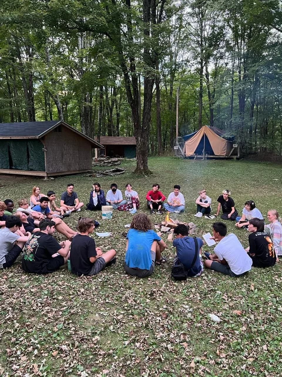 Campers in a council circle between the cabins